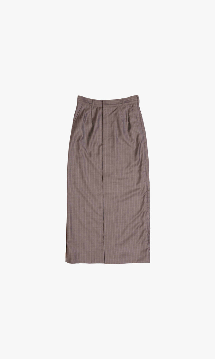 SIEGENTHALER | Front view of the V1 skirt in grey pinstripe wool, styled with matching blazer, featuring layered button closures, asymmetric draping, and exposed copper lining.