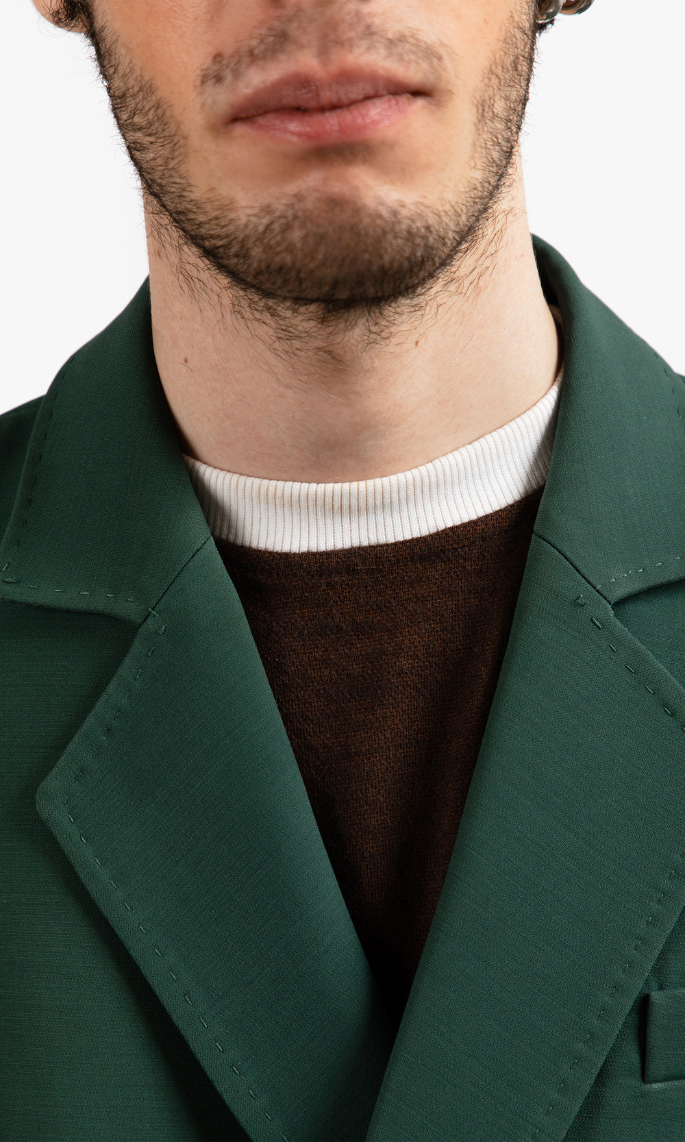 SIEGENTHALER | Close-up of the suit jacket's side drawstrings with hidden loops for adjustable drape in dark green wool-silk mikado.