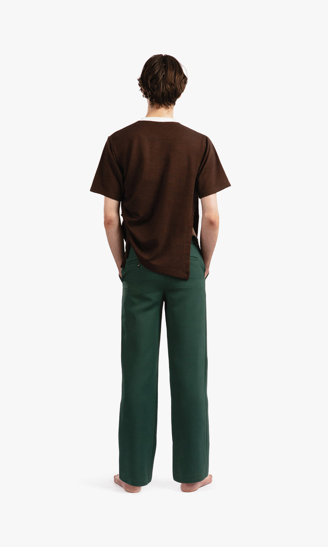 SIEGENTHALER | Rear view of tailored pants in dark green, featuring two single welt pockets with button closures and meticulous topstitching.