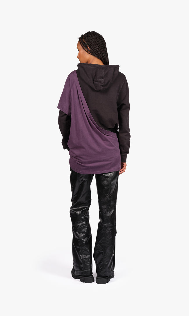 SIEGENTHALER | Back view of the black faux leather pants with chaps, featuring a multi-panel construction and sleek seamwork. The modular chaps integrate seamlessly into the structure, while rear vertical lines and hem zips offer movement and sculptural balance.
