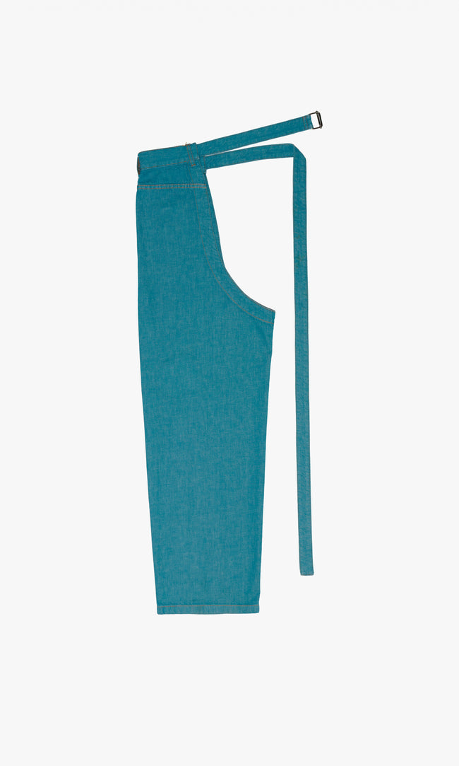 SIEGENTHALER | Back view of the denim chap in storm blue, displaying the straight-cut silhouette and four belt loops at the waist.