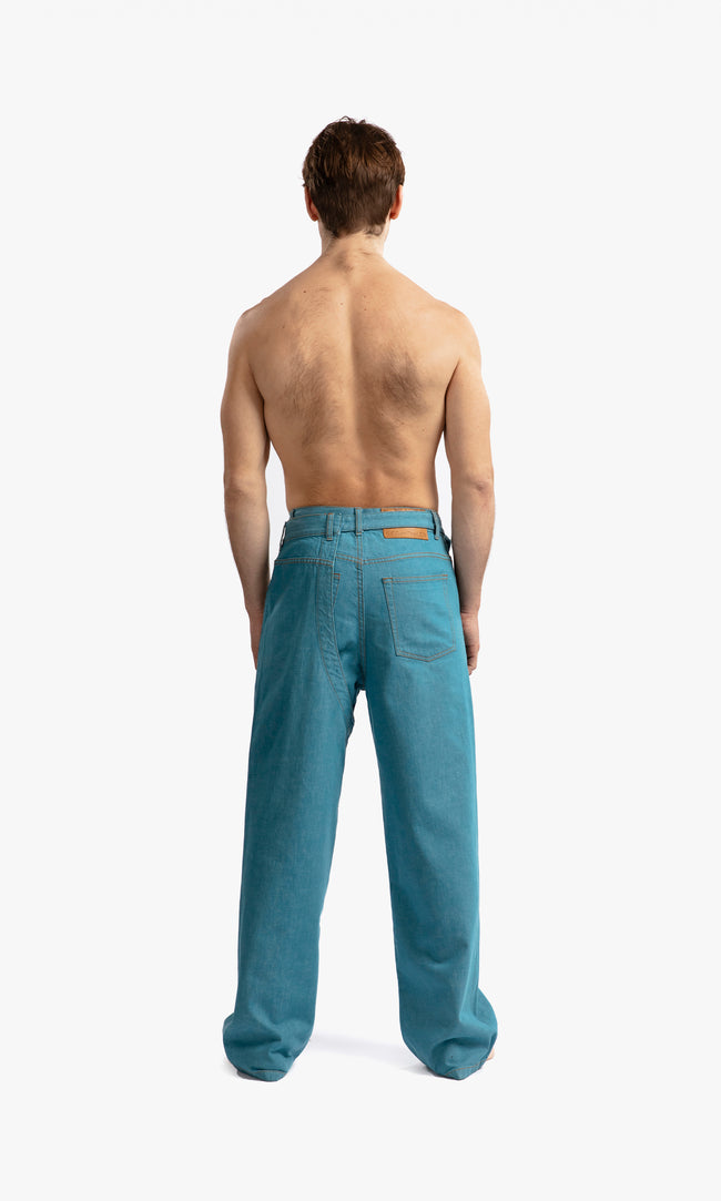 SIEGENTHALER | Back view of the denim chap in storm blue, displaying the straight-cut silhouette and four belt loops at the waist.