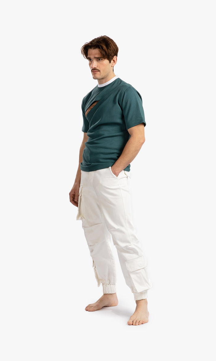 SIEGENTHALER | Side view of the Hildegard T-Shirt in Balsam Green, highlighting the cut-out detail and separable shoulder with invisible snap closures.